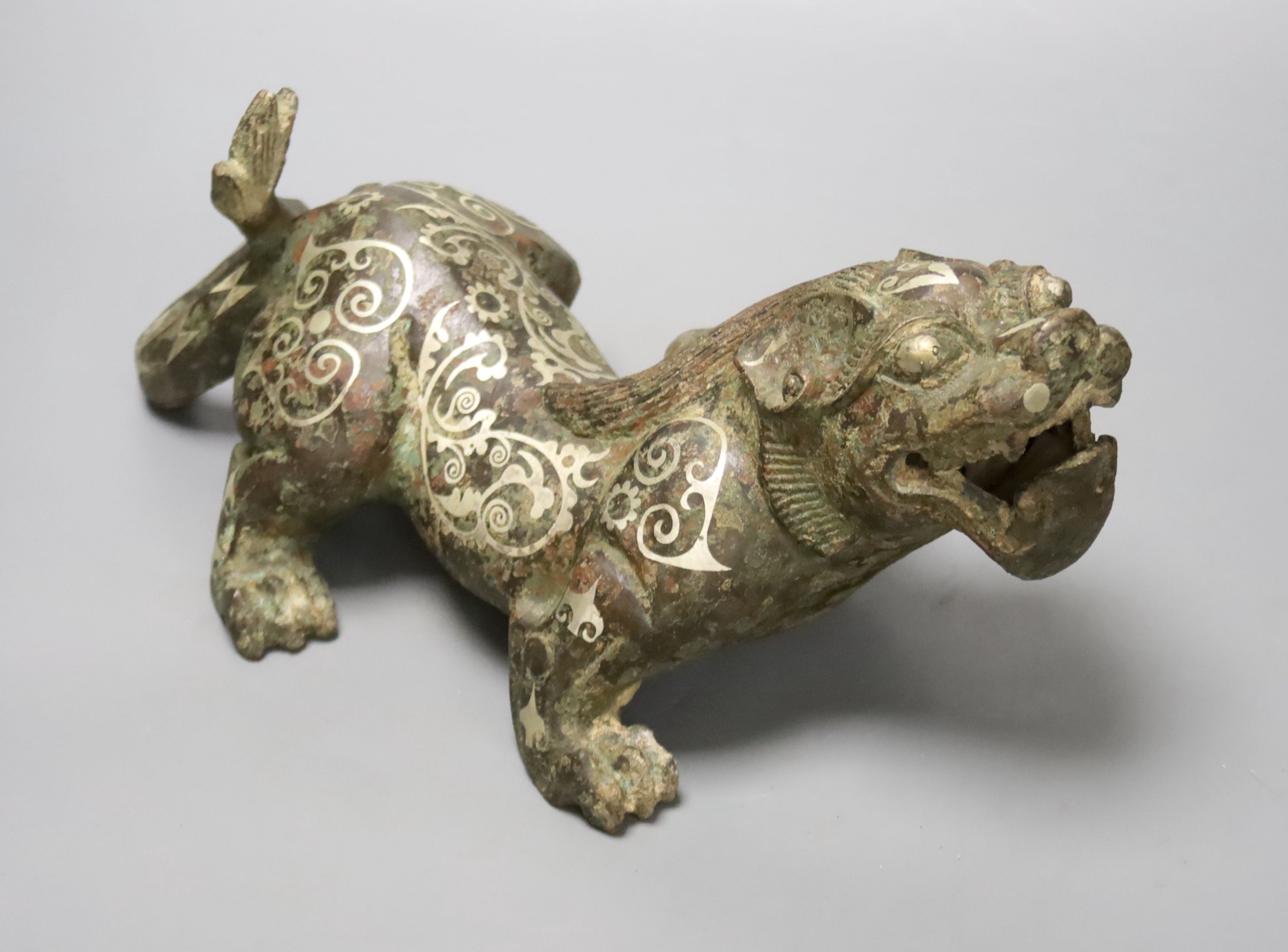 A Chinese inlaid bronze figure of a lion dog, Han dynasty style